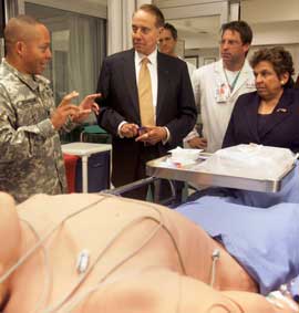 Lt. Col. Donald Robinson, M.D. (left), who runs the Army Trauma Training Center, demonstrates a patient simulator to former Senator Robert Dole and UM President Donna Shalala, as Mark McKenney, M.D. co-director of the Ryder Trauma Center, looks on.