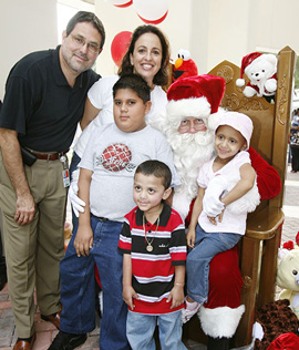 ‘Tis the time of year for charity and good cheer, and the Miller School is embracing it wholeheartedly with a handful of holiday-themed events. Pictured from left, Julio Barredo, M.D., Toppel Family Professor and director of pediatric hematology/oncology; Colleen M. Mourra, executive director of the Kids & Families Foundation; Armando Sosa, 10; Commissioner Jose “Pepe” Diaz as Santa; Indiana Sosa, 4; and David Rodriguez, 4.